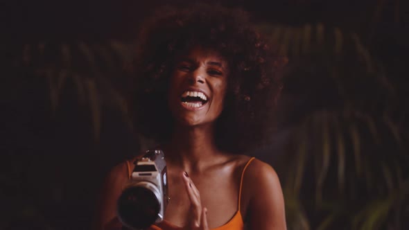 Woman With Afro Hair In Orange Dress Using Vintage 8Mm Camera