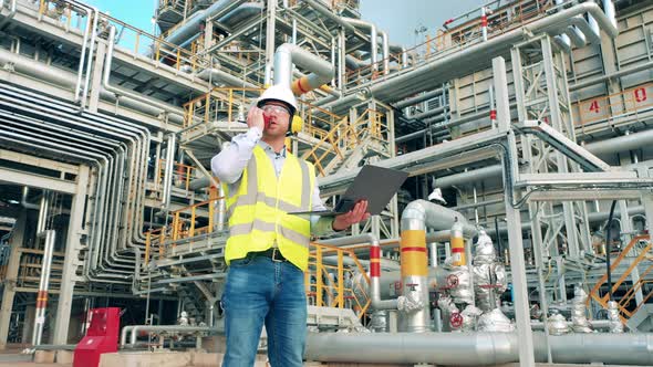 Pipes of the Oil Refinery with an Engineer Talking Over the Radio Nearby