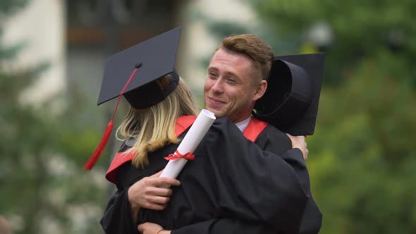 Sincere Emotions of Cheerful Male and Female Graduates Hugging and Laughing