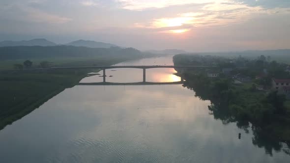 Flycam Moves From High Long Bridge Over Wide River at Sunset