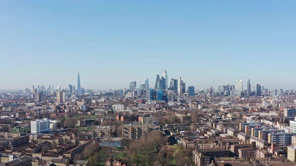 Slider drone shot over residential buildings tower hamlets towards city of London skyscrapers