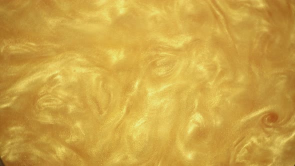 Golden Glitter Paint Texture Abstract Background. Liquid Glitter Movement