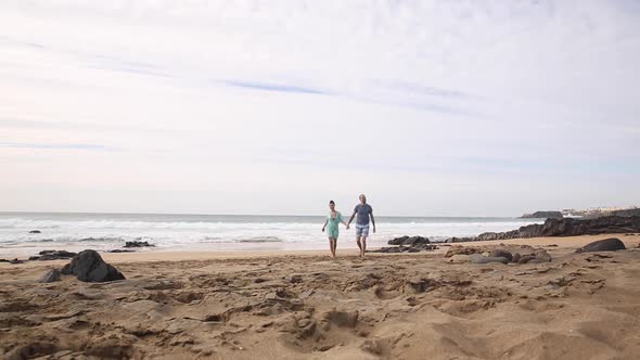 Happy couple in love spending time together at seaside in Fuerteventura walki