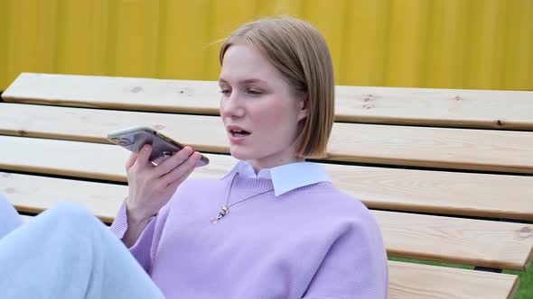 Young Woman Blonde Records Voice Message on Smartphone