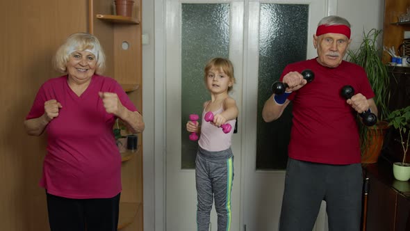 Active Senior Couple Grandmother Grandfather with Child Kid Girl Doing Fitness Dumbbells Exercises