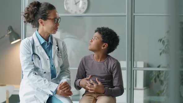 Portrait of Happy African American Boy and Female Doctor in Clinic