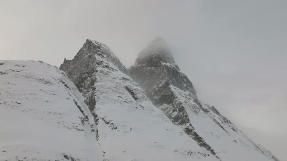 Aerial drone shot snow covered Otertinden mountain in Troms, Finnmark. Northern Norway.  Summit hid