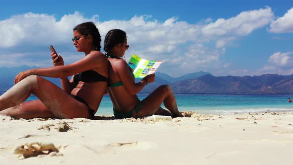 Sexy beauty models on photoshoot having fun at the beach on paradise white sand and blue background 