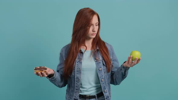 Close Up of an Young Woman Choosing Between Apple and Donuts, the Girl Choose Apple.