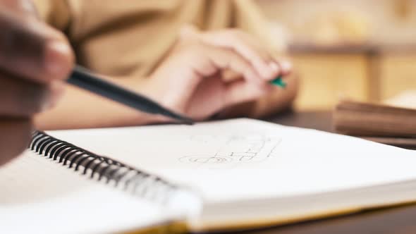 African American child and his parent drawing in copy-book