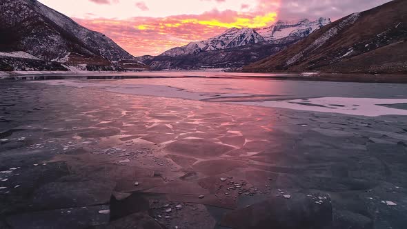 Vibrant sky glowing reflecting off ice on lake through the texture