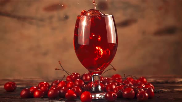 Super Slow Motion in a Glass with Cherry Juice Drops Fresh Cherry