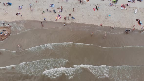 Revealing aerial footage of a crowded beach along a North Sea city shore of Zandoort, Netherlands.