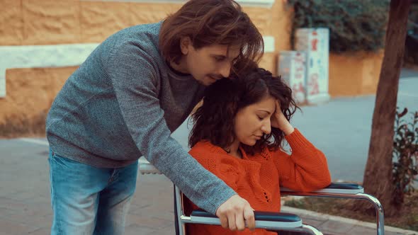 empathy, closeness - young man tries to comfort his girlfriend with paraplegia