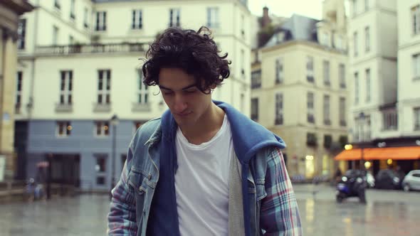 Front view of a young man walking in the streets of Paris