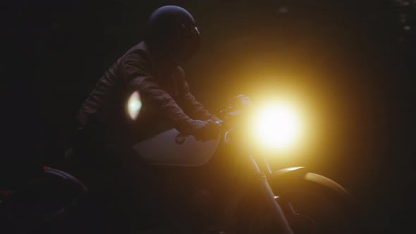 Motorcycle With Headlights on in the Dark Background Tracking Shot