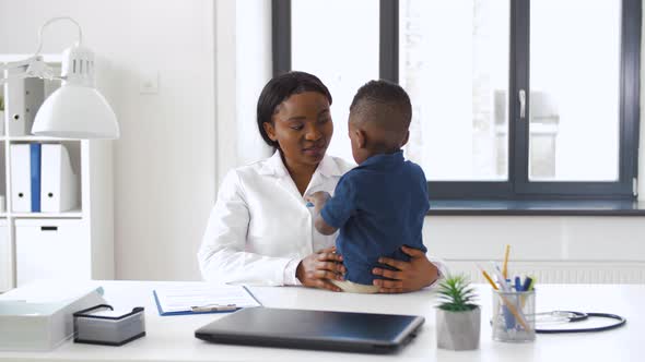 Doctor or Pediatrician with Baby Patient at Clinic