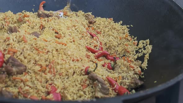 Big Vat with Cooked Pilaf or Rice Over an Open Fire. Street Food at the Party