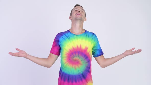 Studio Shot of Happy Man with Tie-dye Shirt Closing Eyes and Relaxing