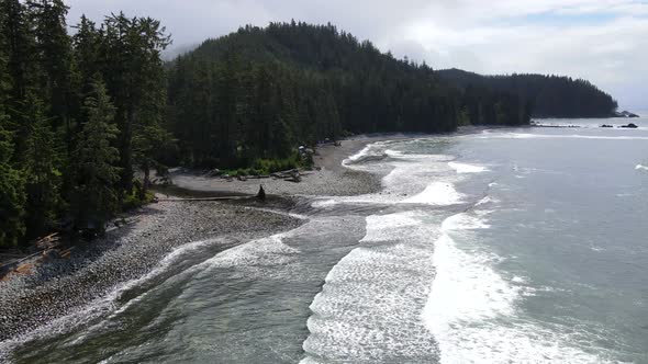 Aerial footage in 4k of Sombrio beach on a cloudy day during spring of 2021. Big waves crashing on t