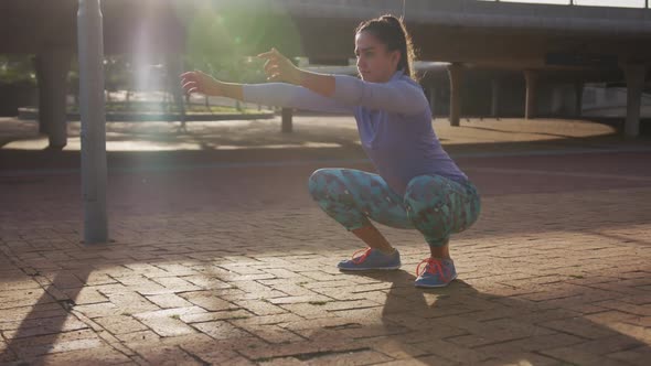 Caucasian woman doing squats in a park