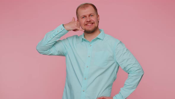 Joyful One Man in Blue Shirt Looking at Camera Doing Phone Gesture Like Says Hey you Call Me Back