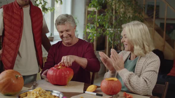 Family Applauds and Rejoices That Grandpa Made a Pumpkin for Halloween