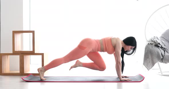 Woman doing abdominal exercises on mat at home.