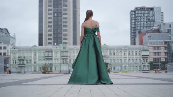 Back View of Gorgeous Girl in a Stunning Evening Green Dress Walking Fascinatingly on Empty City