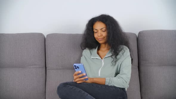 Happy black female calling on video with modern smartphone