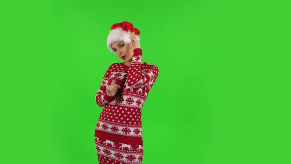 Sweety Girl in Santa Claus Hat Is Coquettishly Smiling While Looking at Camera, Green Screen