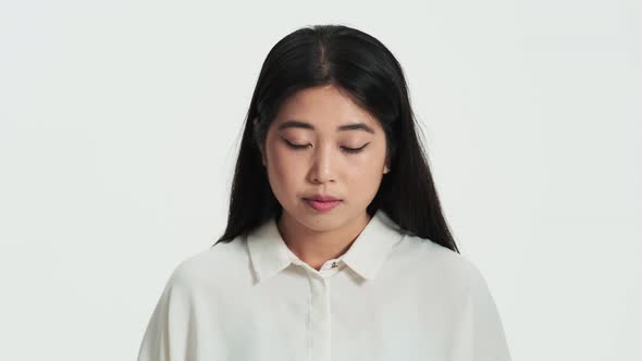 Close-up view of a calm pleased asian korean woman opening her eyes