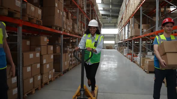 Cheerful Woman Riding Pallet Jack in Warehouse