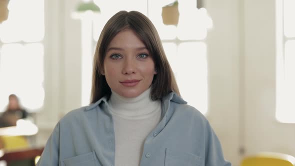 Portrait of Adorable Woman with Blue Eyes Posing at Cafe