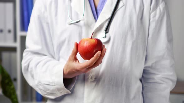Doctor Or Nutritionist Is Holding Beautiful Juicy Apple. Medical Nutrition, Healthcare. Young Woman