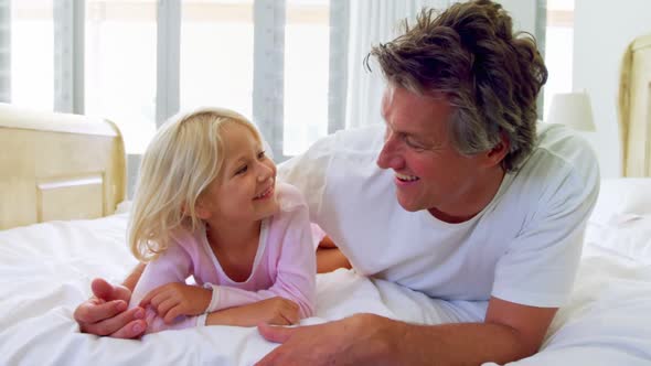 Father and daughter having fun in bedroom