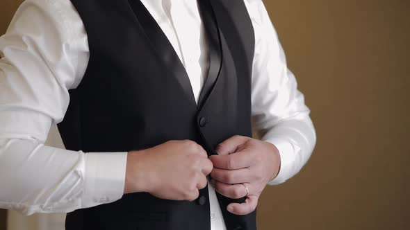 Groom Buttoning Jacket Man in Suit Fastens Buttons on His Jacket Preparing to Go Out