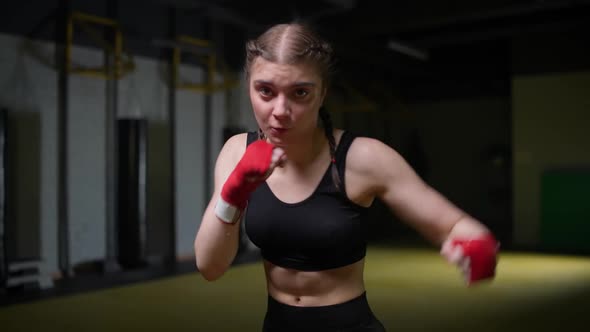 Female Fighter Trains His Punches Training in the Boxing Gym Young Woman Looks at the Camera and