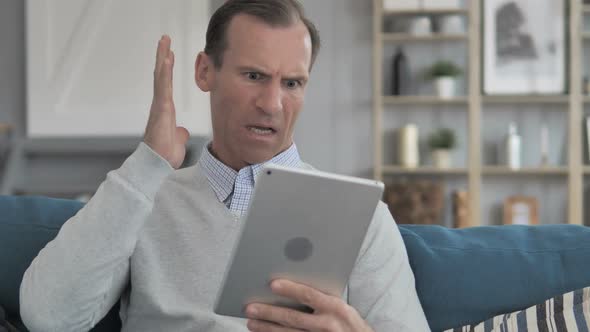 Wondering Middle Aged Man in Shock By Loss While Using Tablet