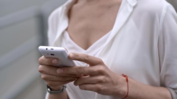 Closeup of Female Hands Using Smartphone Outdoors