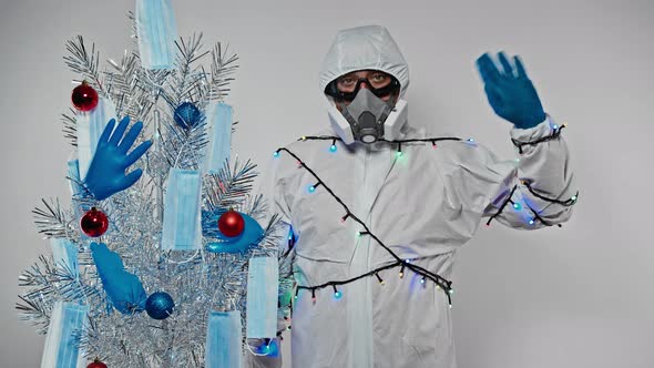 Virusologist (Doctor,scientist) Wearing a Protective Suit and Garland Waves a Hand Standing Next To