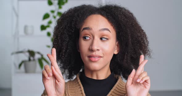 Portrait of Smiling Afro American Woman Ethnic Girl Smiles Crosses Fingers Dreaming Strongly Wishes