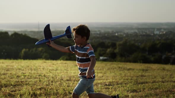 Video of boy running with a plane outdoors. Shot with RED helium camera in 8K.