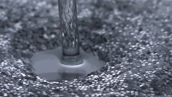 Pouring water into water filled with glitter, Slow Motion