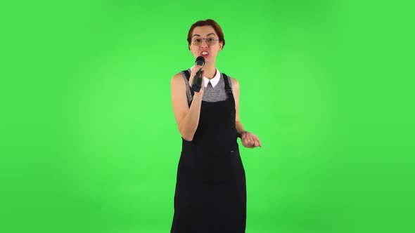 Funny Girl in Round Glasses Is Singing Into a Microphone and Moving To the Beat of Music. Green