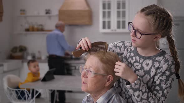 Kind Granddaughter Combing Hair of Disabled Granny