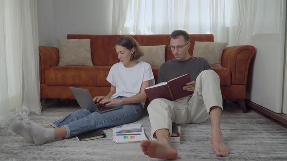 a Couple of Students Study at Home Reading and Typing on a Laptop Home Education