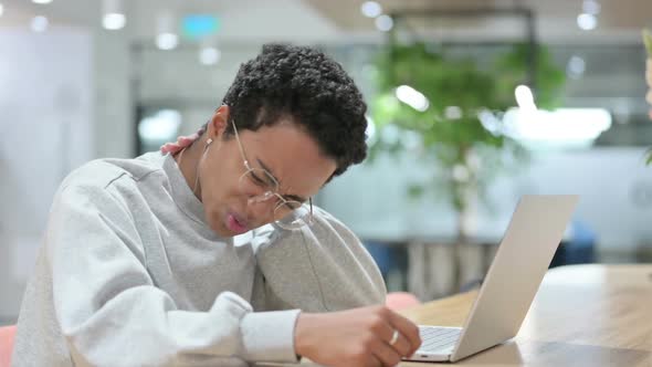 Casual African Woman with Laptop Having Neck Pain