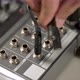 close-up hand plugging a cable into the sound or audio mixer - VideoHive Item for Sale