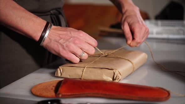 Sideview of Man's Hands Wrapping the Present